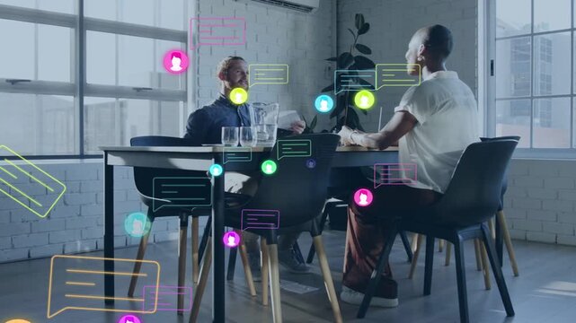 Man listening while woman gesturing, chat icons appearing around table visualizing business chat