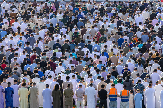 Mulhouse, France - 27 May 2026: View of a large crowd of Muslim men gathered for prayer at the Stade de l'Ill stadium, wearing traditional robes under bright daylight.