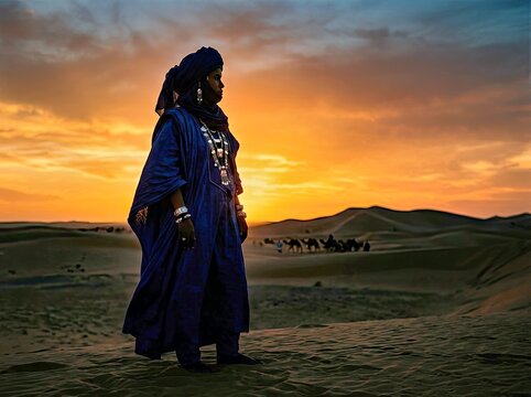 Sahara Nomad at Sunset: A lone Tuareg nomad, adorned in traditional blue robes and headwrap, stands silhouetted against a fiery desert sunset.