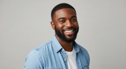 Obraz premium Portrait of a Happy Young African American Man with a Beard Smiling Confidently Against a Gray Background