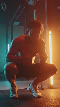Male athlete performing functional training exercises in a dimly lit gym environment focusing on strength, conditioning, and body control for overall fitness and performance enhancement