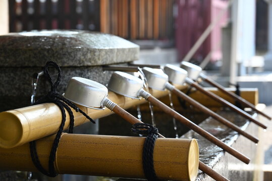 気比神宮の手水舎に並ぶ柄杓と清らかな湧き水  
Purification ladles and flowing water at the temizuya of Kehi Jingu Shrine
