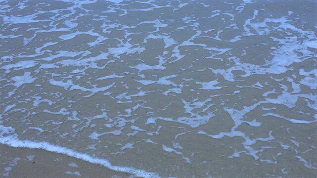Quiet Seaside View With Soft Waves Kissing Sandy Shore And Bubbles. Peaceful Maritime Landscape Featuring Gentle Ocean Waves Caressing Sandy Coastline And Creating Soothing Bubbles