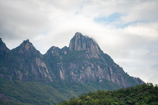A view of the majestic Lingshan Mountain surrounded by lush green forests and clouds in Shangrao China