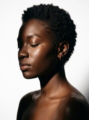 Obraz premium Side profile of young Black woman with short natural hair and eyes closed with glowing dewy skin, natural beauty and skincare concept on white background
