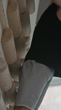 Vertical video of athletic man training on wooden pegboard climbing wall in gym. Clip is ideal for fitness apps, sports brand commercials, and athletic training promotions