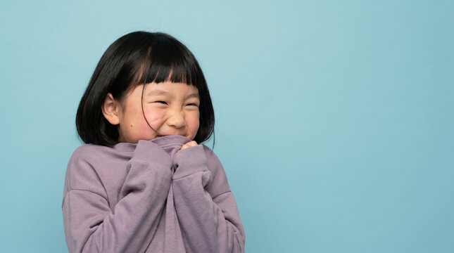 Shy Young Asian Girl Hiding Behind Oversized Purple Sweater Sleeves