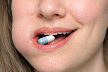 Naklejka premium A close-up shot of a woman taking a pill, suitable for health and wellness themed projects