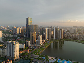 Fototapeta premium Sunset cityscape of Cau Giay district with office towers, busy streets and urban lake in Hanoi Vietnam.