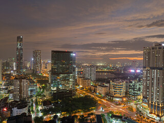 Obraz premium Wide aerial panorama of modern Hanoi skyline featuring multilane roads, residential towers, and green urban landscapes beside a lake.