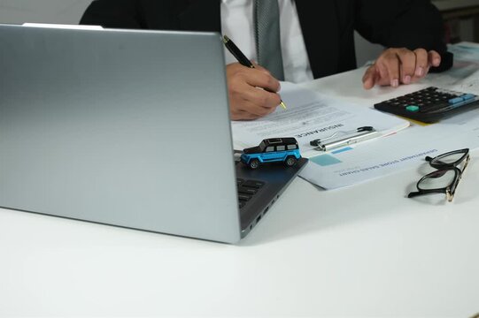 Businessman checks car insurance documents before agreeing and signing insurance documents, contracts or vehicle sales.