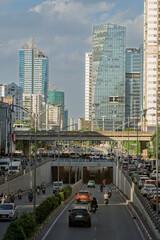 Fototapeta premium Busy traffic entering Le Van Luong underpass surrounded by modern office towers and urban infrastructure in Hanoi Vietnam.