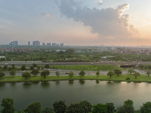 Sunset panorama of National Highway 5B running through Gia Lam district with lakeside greenery and expanding urban landscape in Hanoi Vietnam.
