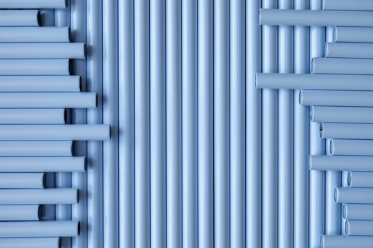 Light blue tubes arranged in vertical and horizontal patterns forming abstract industrial geometric background