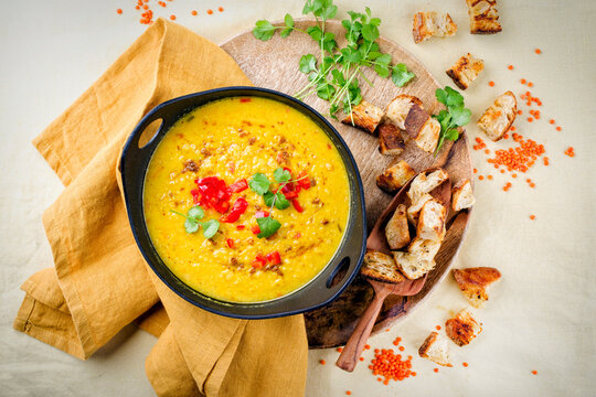 Traditional Indian style dal lentil soup dal tadka with roasted flatbread served as top view in a design pot