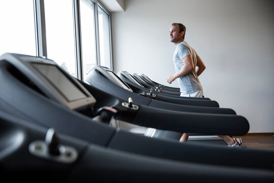 Man Running on a Treadmill in a Modern Fitness Studio