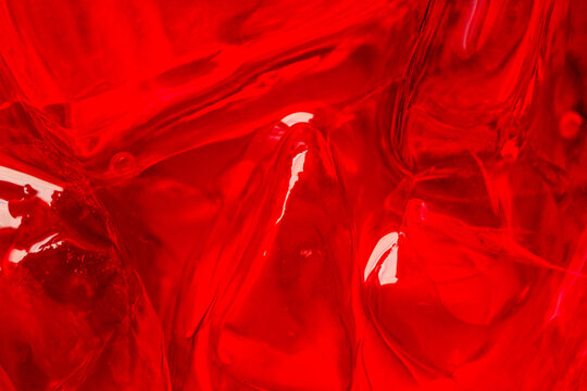 Abstract Macro View of Vibrant Red Gelatin Texture,A close-up, high-contrast abstract macro shot capturing the smooth, fluid, and translucent texture of vibrant red gelatin with soft highlights.