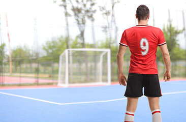 Obraz premium Football player in a red jersey with number 9 from behind