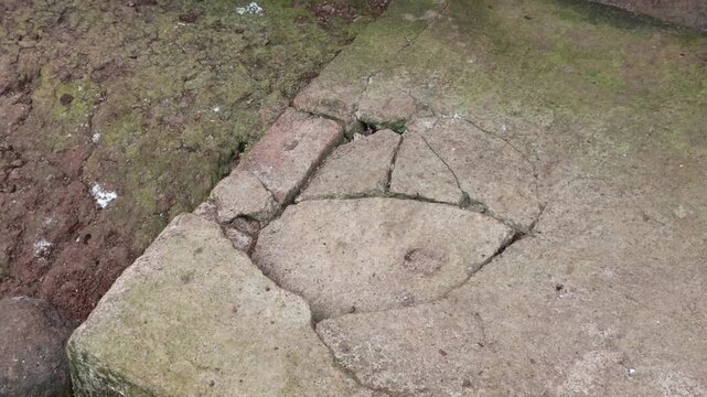 Detailed shot of a damaged, severely cracked concrete cement floor corner on a backyard ground.