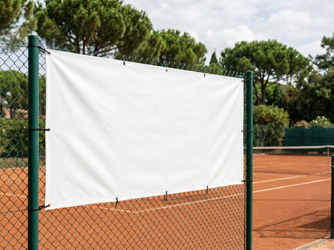 Blank white advertising banner on chain link fence at tennis court