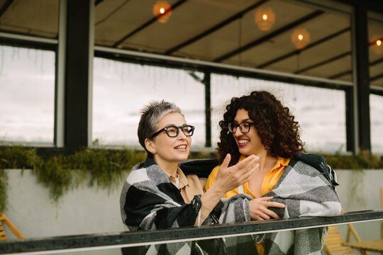 Two women sharing generational friendship moments on balcony