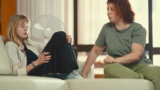 Concerned mother admonishing her teenage daughter at home