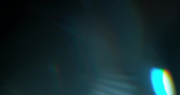 Slow motion of lens flare isolated on black background. Colored spectrum. Cinematic glowing light overlay with optical streaks and rays for VFX compositing and transitions.
