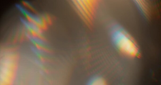 Slow motion of lens flare isolated on black background. Colored spectrum. Cinematic glowing light overlay with optical streaks and rays for VFX compositing and transitions.
