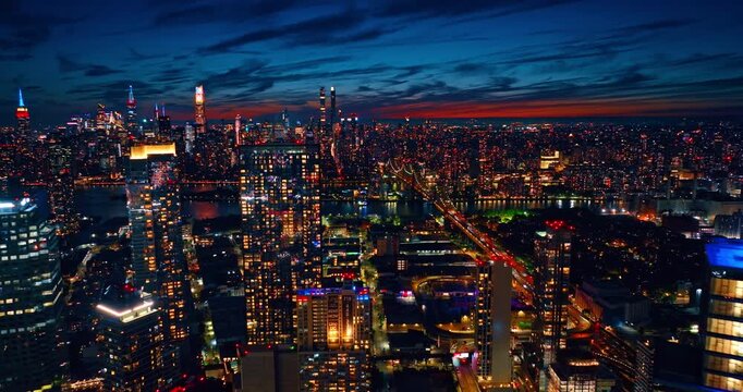 Night flight over amazing luminous cityscape of metropolis. Lively traffic around the streets of New York City, USA.