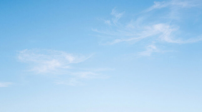 Gentle light blue sky adorned with delicate, swirling white wisps of cirrus clouds.