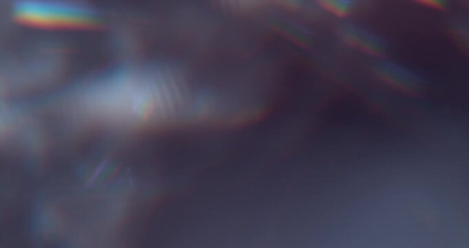 Slow motion of lens flare isolated on black background. Colored spectrum. Cinematic glowing light overlay with optical streaks and rays for VFX compositing and transitions.