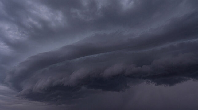 Ominous dark storm clouds gathering in the sky, foretelling severe weather and a heavy, impending thunderstorm.