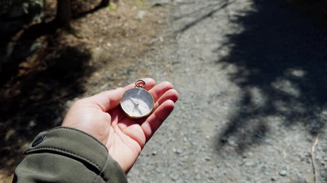 A person explores a serene forest trail, holding a vintage compass to guide their journey. The warm sun filters through the trees, illuminating the peaceful surroundings