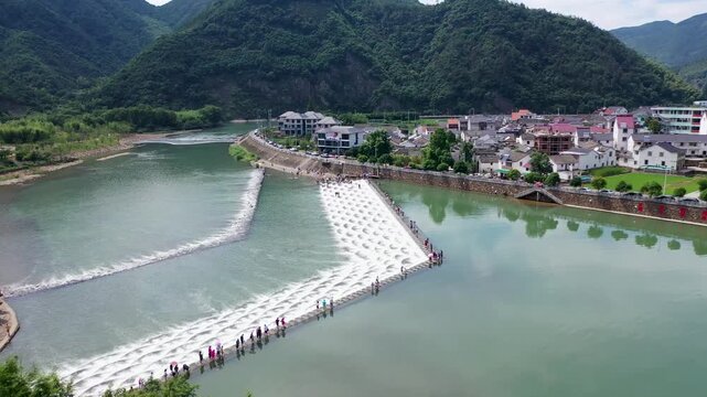 Stepped River Weir Flowing Beside Rural Village