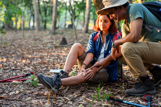 Hikers assist injured woman outdoors.