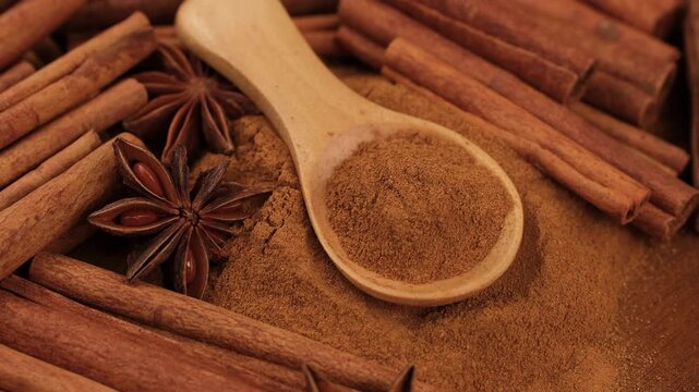 Cinnamon powder and cinnamon sticks close up, rotation. Warm, aromatic spice is a staple in baking and cooking