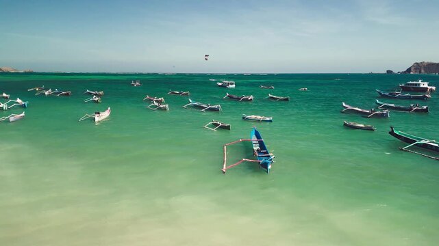 Aerial drone view of Kuta Beach Lombok Indonesia on a sunny day showing white sand surf waves and turquoise ocean waters