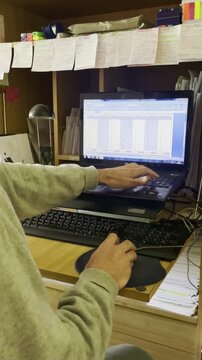 Usando ordenador port&aacute;til y trabajando a distancia con teclado keyboard laptop con rat&oacute;n mouse en escritorio de oficina despacho con notas post it