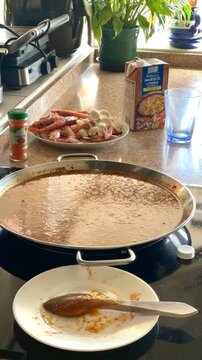 Paella de arroz time lapse cocci&oacute;n ingredientes y proceso elaboraci&oacute;n plato t&iacute;pico paellera cocer y humo dando vueltas cuchara paso a paso en vitrocer&aacute;mica cocina