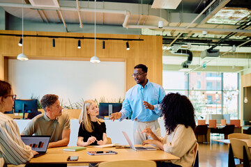 Group of diverse businesspeople collaborating during a discussion, planning a new strategy in a modern office environment © we.bond.creations