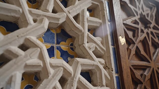 Intricate geometric patterns carved into wooden and plaster architectural elements.