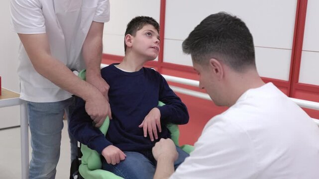Orthopedic technicians creating custom wheelchair seating for a disabled child