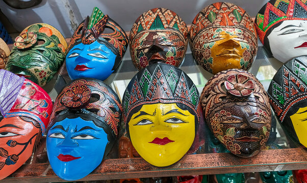hand-carved wooden Indonesian masks decorated with colorful batik patterns and character expressions from Javanese and Balinese folklore. Close up view.
