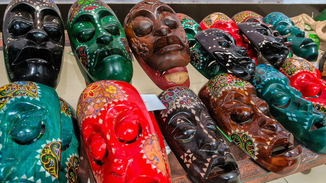 hand-carved wooden Indonesian masks decorated with colorful batik patterns and character expressions from Javanese and Balinese folklore. Close up view.