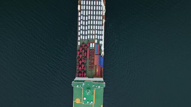 aerial view, A ship loaded with cars is anchored at the port in Halifax, Canada. The cargo ship prepares for export while containers are visible on deck. This is a busy area for car transport