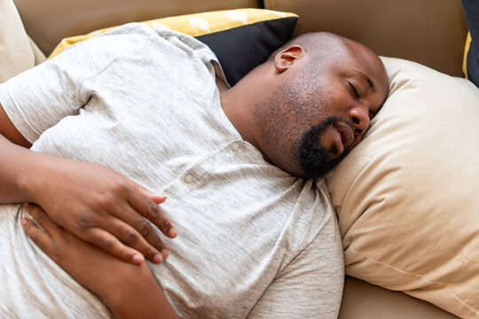 Man peacefully sleeping on couch.