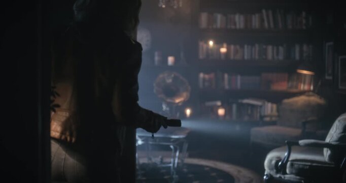 Cautious woman entering hazy, creepy home with candles and gramophone - medium tracking shot