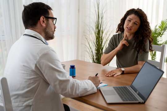 Female patient discussing thyroid issues with endocrinologist in office
