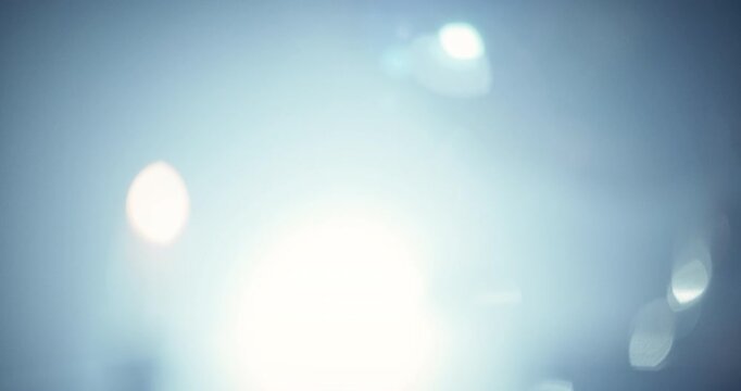 Flare of flashlight as young woman enters hazy, dark home and looking at small notebook - medium handheld shot