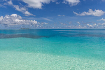 Fototapeta premium Stunning tropical ocean view distant island turquoise lagoon blue sky white clouds horizon. Dreamy paradise escape summer holiday, exotic vacation relaxation wellness mindfulness travel destination ca
